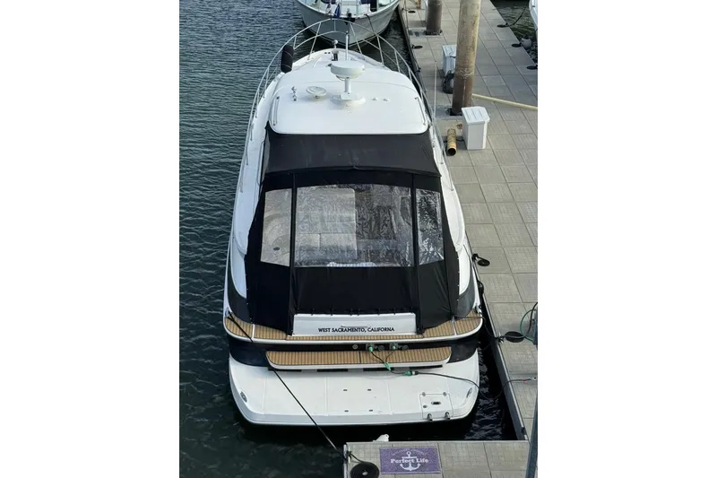 Slide: The Image of 2006 Regal Commodore 4460 yacht docked at marina, rear view with black canopy. - 11