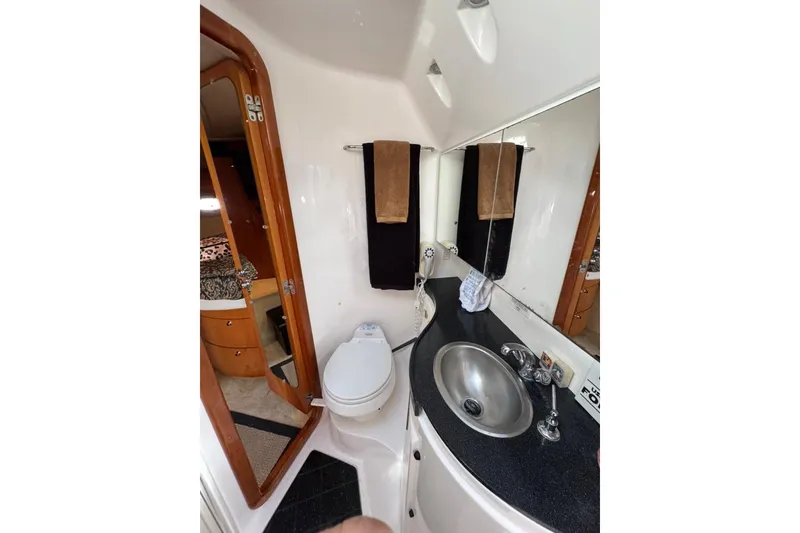 Slide: The Image of 2006 Regal Commodore 4460 yacht bathroom with sink, toilet, and mirror. - 14
