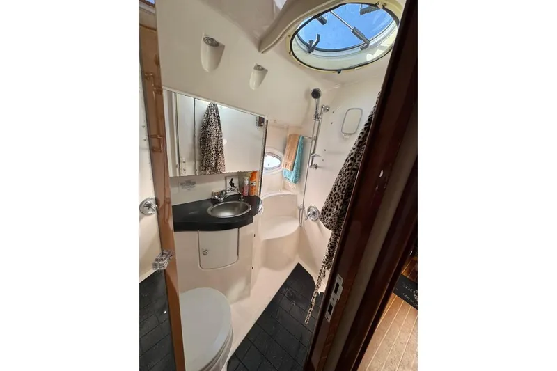 Slide: The Image of 2006 Regal Commodore 4460 yacht bathroom with sink, shower, and porthole window. - 16