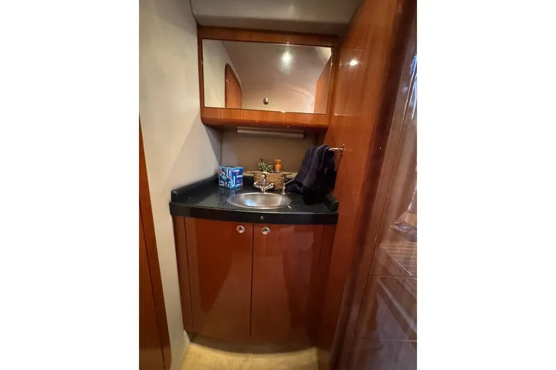 Slide: The Image of 2006 Regal Commodore 4460 yacht bathroom with wooden cabinetry and sleek sink design. - 20