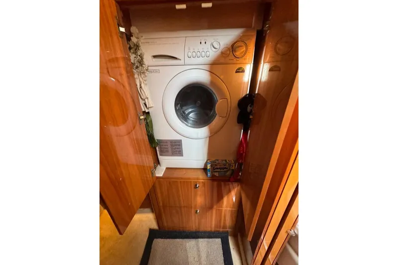 Slide: The Image of Laundry area inside 2006 Regal Commodore 4460 yacht with washing machine and storage. - 21