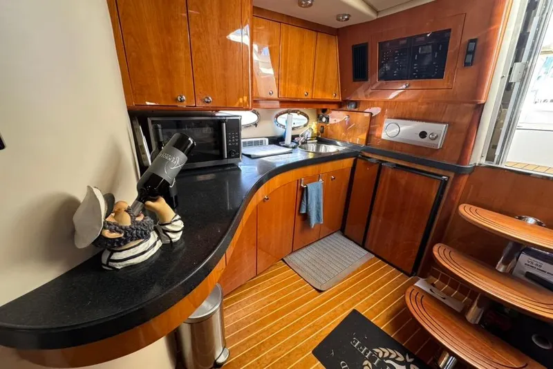 Slide: The Image of Luxurious 2006 Regal Commodore 4460 yacht kitchen with wooden cabinetry and modern appliances. - 26