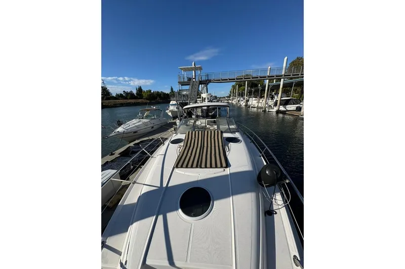 Slide: The Image of 2006 Regal Commodore 4460 yacht docked at marina under clear blue sky. - 28