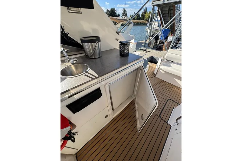 Slide: The Image of 2006 Regal Commodore 4460 yacht with open cabinet and sink on deck. - 32