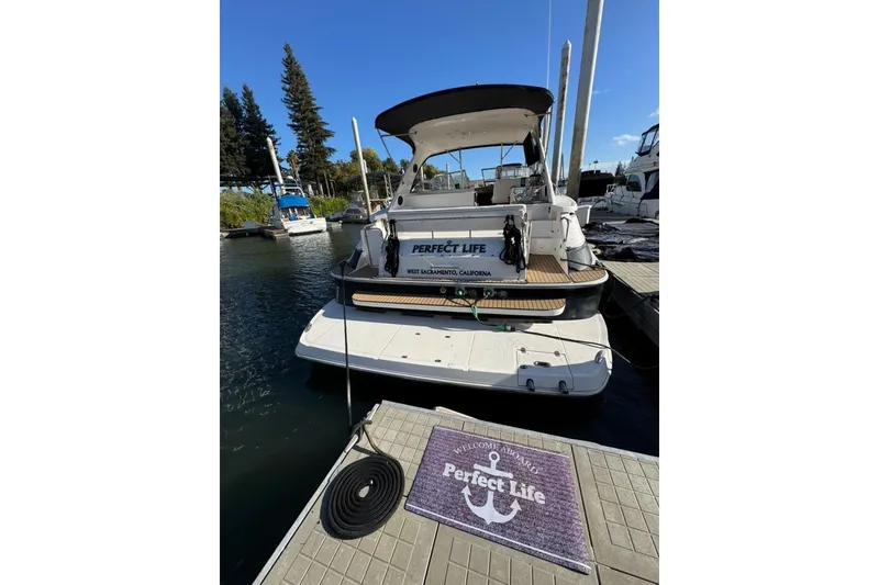 Slide: The Image of 2006 Regal Commodore 4460 yacht docked, featuring "Perfect Life" signage and welcome mat. - 35