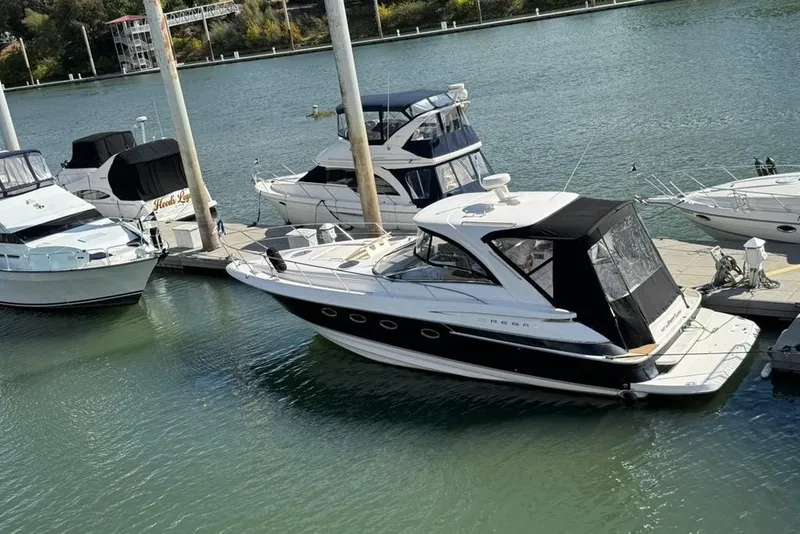 Slide: The Image of 2006 Regal Commodore 4460 yacht docked at marina, surrounded by other boats. - 4