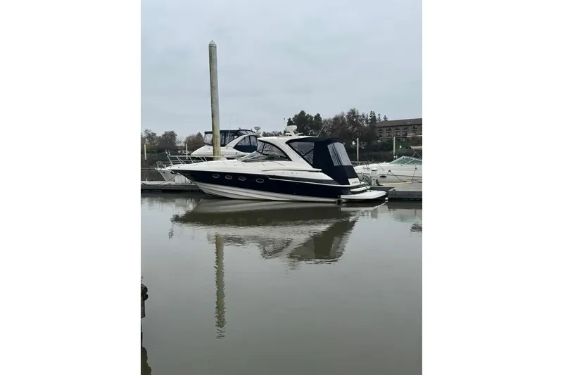 Slide: The Image of 2006 Regal Commodore 4460 yacht docked in a marina, reflecting on calm water. - 43