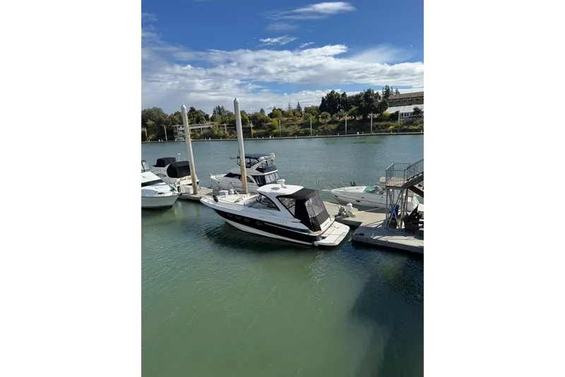 Slide: The Image of 2006 Regal Commodore 4460 yacht docked at a marina under a clear blue sky. - 5