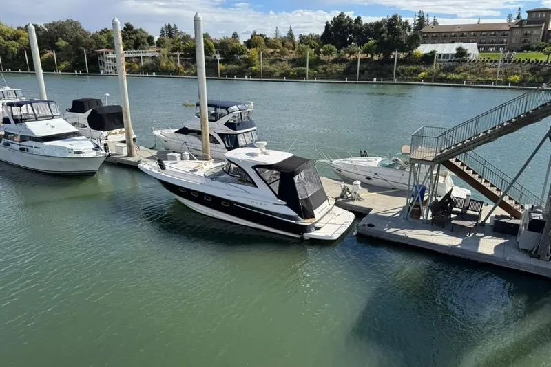 Slide: The Image of 2006 Regal Commodore 4460 yacht docked at marina with other boats, scenic waterfront view. - 6