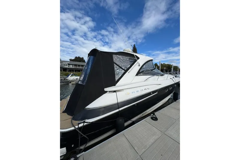 Slide: The Image of 2006 Regal Commodore 4460 yacht docked under a blue sky. - 8