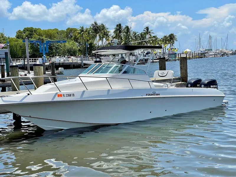 The Image of 1993 Fountain Walk Around boat docked in a marina with palm trees and clear skies. - 1