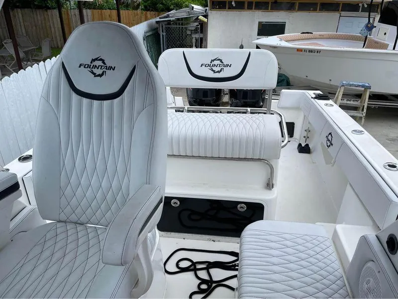 Slide: The Image of 1993 Fountain Walk Around boat interior with white quilted seats and logo. - 6