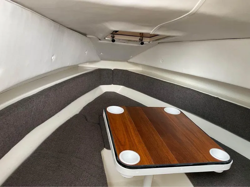 Slide: The Image of Interior cabin of a 1993 Fountain Walk Around boat with a wooden table and seating. - 9