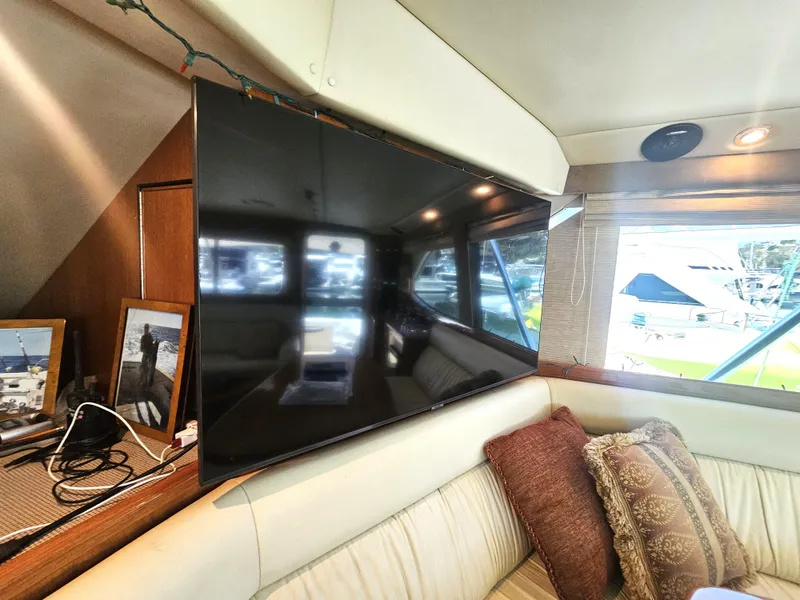 Slide: The Image of Interior of 2005 Riviera 42 Flybridge with TV and cushions. - 24