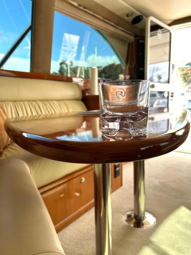 Slide: The Image of Interior of 2005 Riviera 42 Flybridge with elegant wooden table and glass. - 29