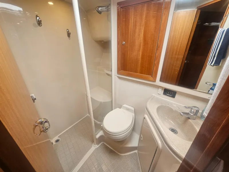 Slide: The Image of Riviera 42 Flybridge 2005 bathroom with shower, toilet, and sink. - 42