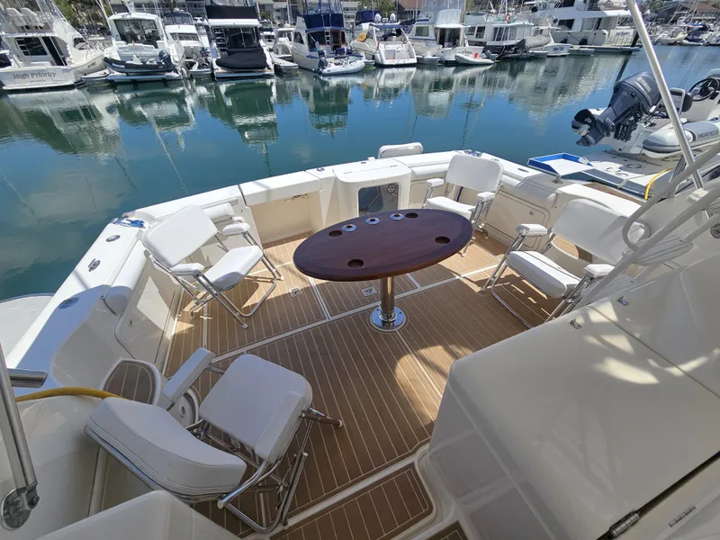 Slide: The Image of Riviera 42 Flybridge 2005 with spacious deck and seating area in marina. - 8