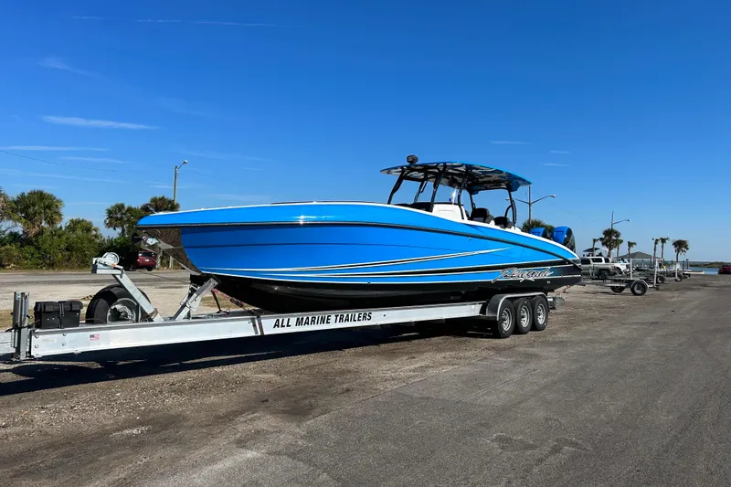 The Image of 2022 Renegade 38' Open boat on trailer, vibrant blue, parked outdoors. - 0