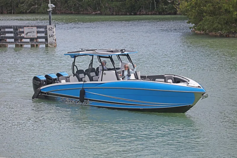Slide: The Image of 2022 Renegade 38' Open boat in blue, cruising on a calm waterway. - 5