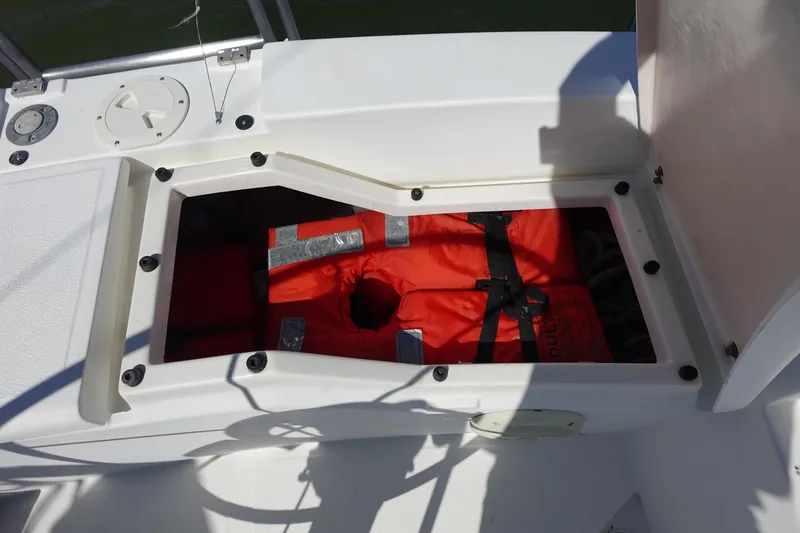 Slide: The Image of Open storage compartment on 1987 Hunter 310 boat with orange life jackets. - 12
