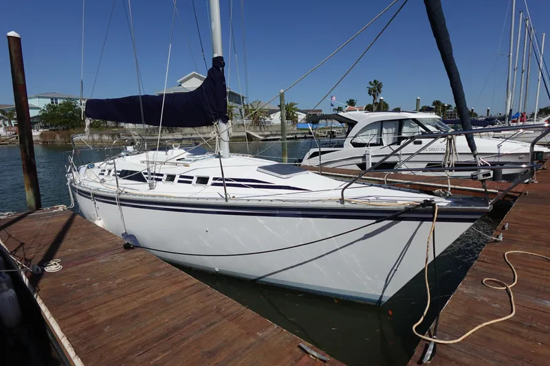 Slide: The Image of 1987 Hunter 310 sailboat docked at marina under clear blue sky. - 2