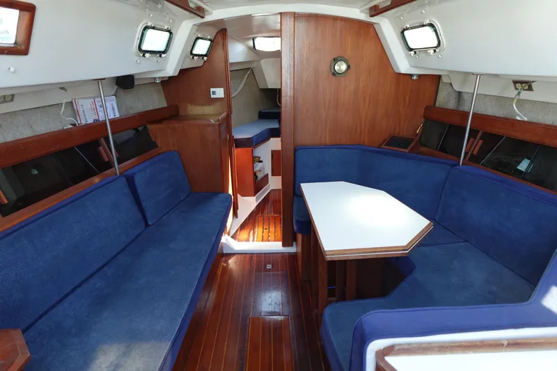 Slide: The Image of Interior of a 1987 Hunter 310 sailboat with blue seating and wooden finishes. - 22