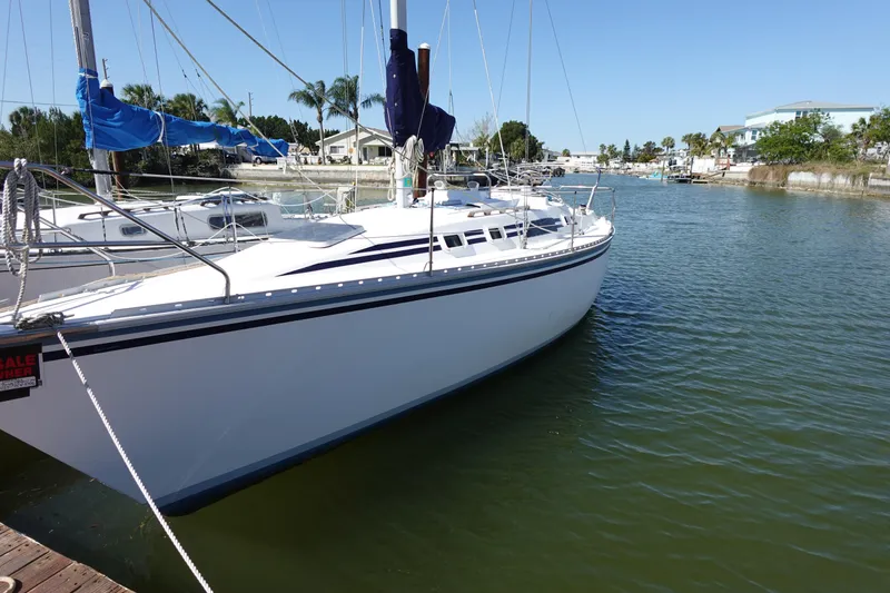 Slide: The Image of 1987 Hunter 310 sailboat docked in a serene marina setting. - 3