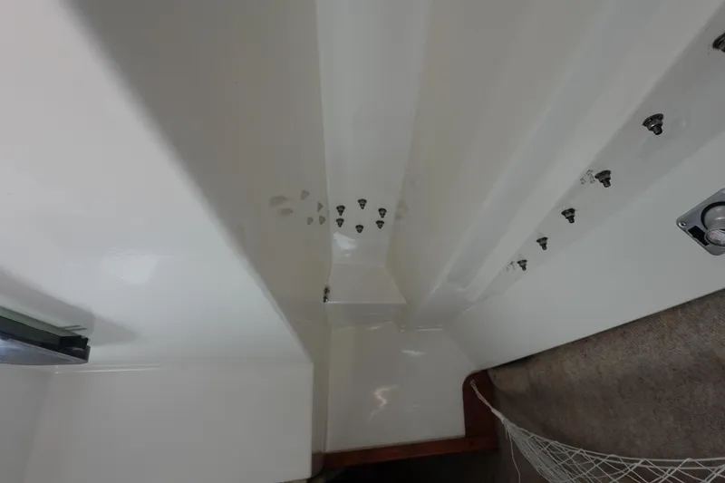 Slide: The Image of Interior view of a 1987 Hunter 310 boat, showcasing white walls and hardware. - 32