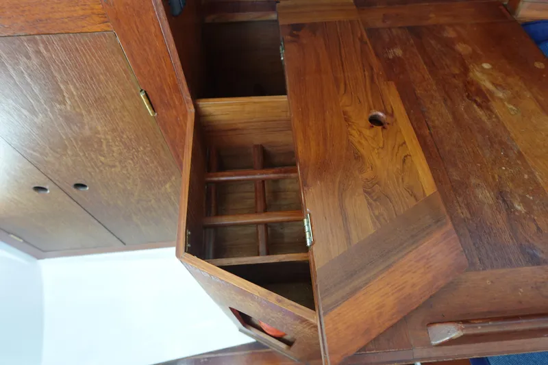Slide: The Image of Wooden interior cabinetry of a 1987 Hunter 310 sailboat, featuring open storage compartments. - 35