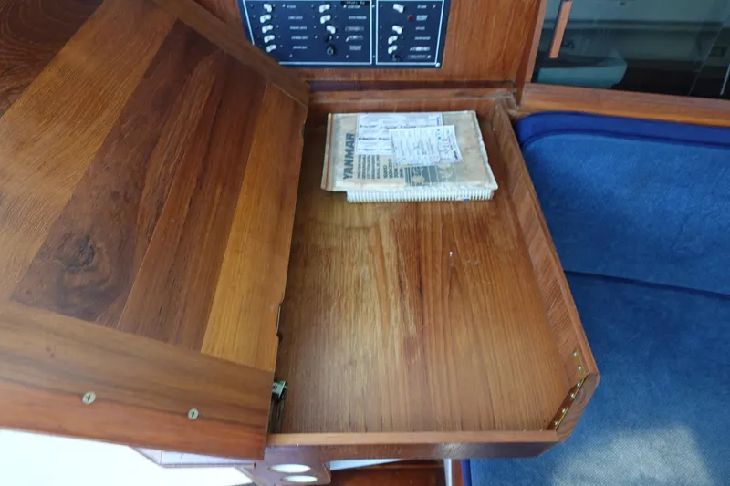 Slide: The Image of Wooden desk with open lid, revealing a manual inside a Hunter 310, 1987 model. - 36