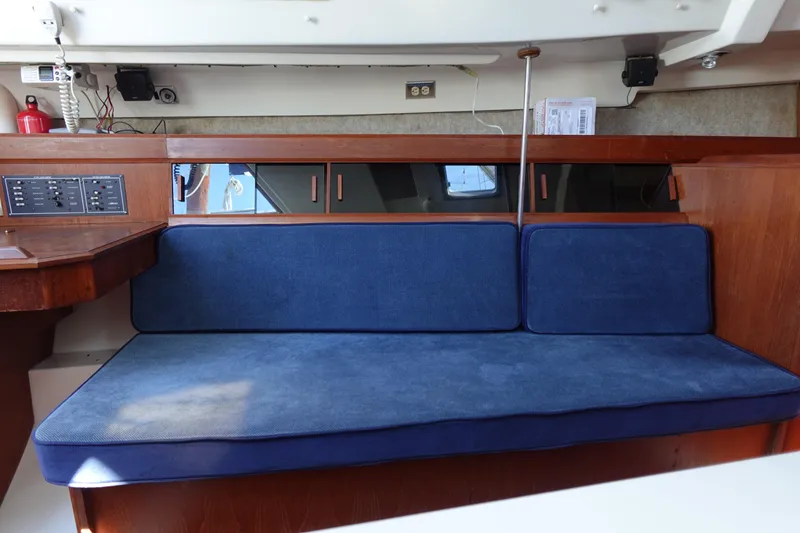 Slide: The Image of Interior of 1987 Hunter 310 sailboat with blue cushioned seating. - 38