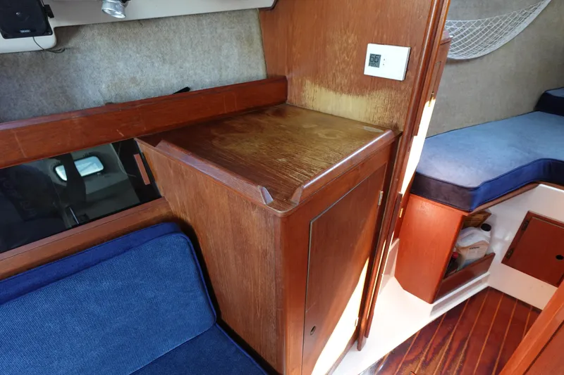Slide: The Image of Interior of 1987 Hunter 310 sailboat with wooden cabinetry and blue seating. - 40