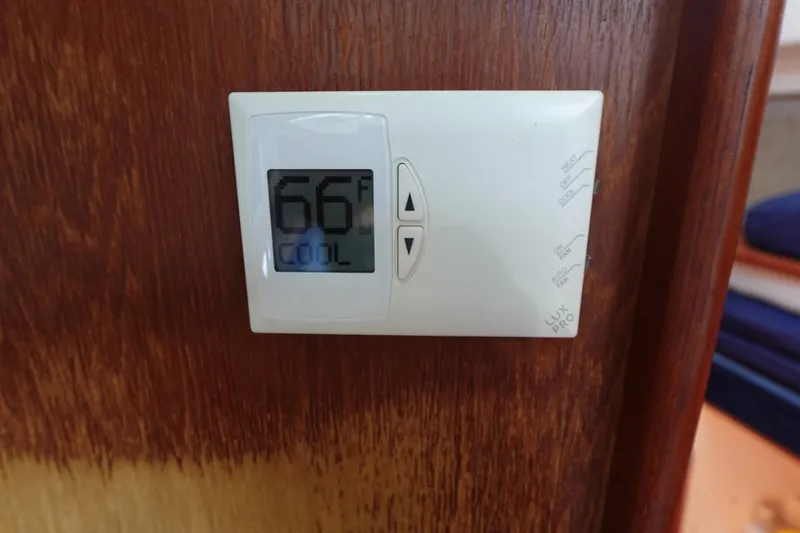 Slide: The Image of Thermostat set to 66°F on a wooden wall, Hunter 310 model, 1987. - 42