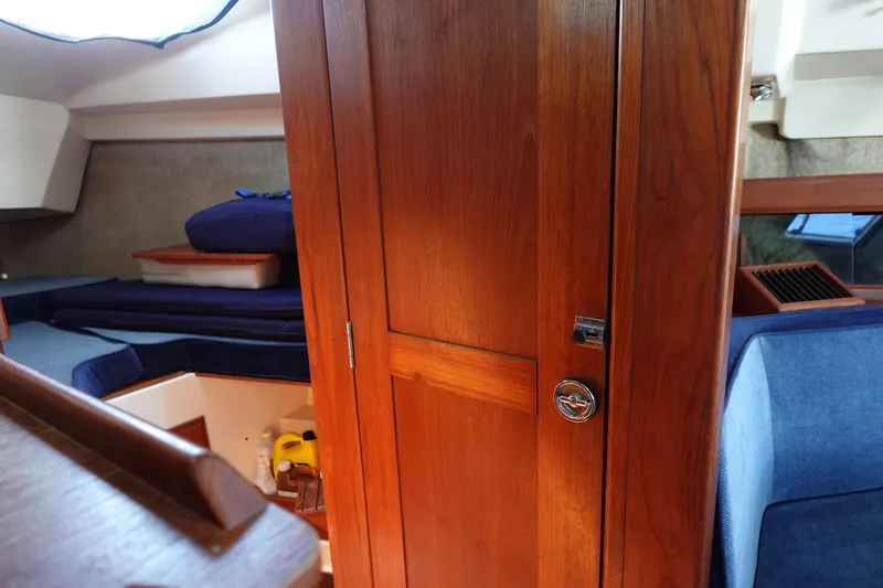 Slide: The Image of Interior of 1987 Hunter 310 sailboat with wooden cabinetry and blue seating. - 43