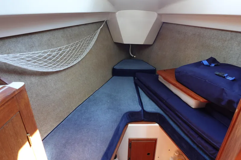 Slide: The Image of Interior cabin of 1987 Hunter 310 sailboat with blue cushions and storage net. - 47