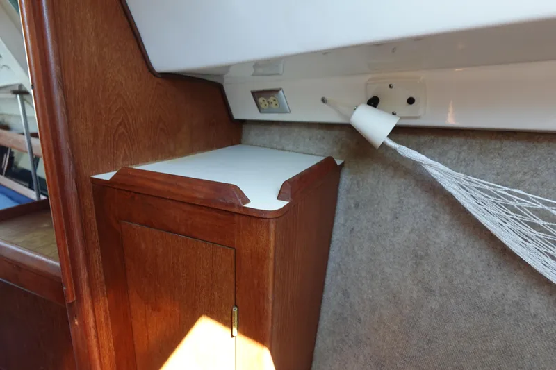 Slide: The Image of Interior of a 1987 Hunter 310 boat with wooden cabinet and netting. - 48