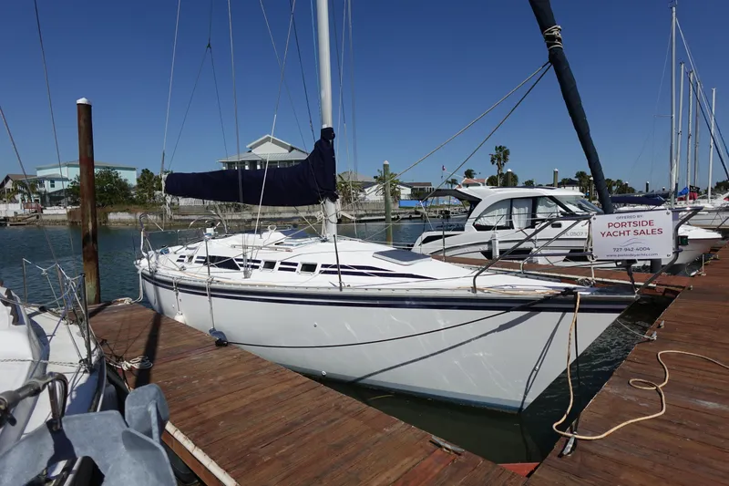 Slide: The Image of 1987 Hunter 310 sailboat docked at marina under clear blue sky. - 5