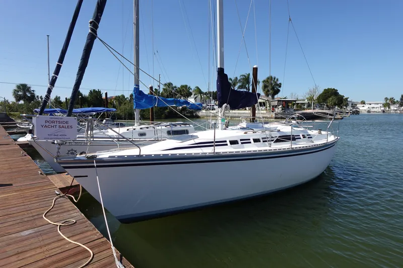 Slide: The Image of 1987 Hunter 310 sailboat docked at marina under clear blue sky. - 7