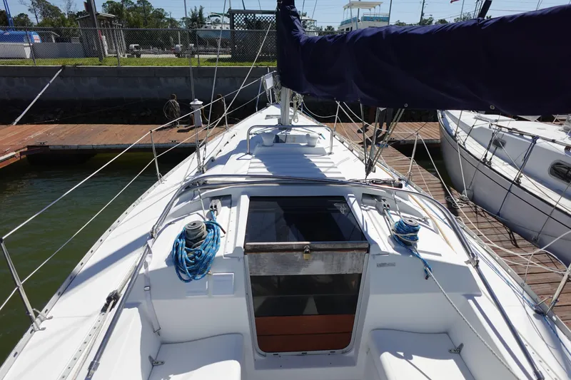 Slide: The Image of 1987 Hunter 310 sailboat docked, showing deck and rigging details. - 9