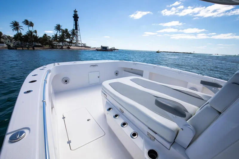 Slide: The Image of 2021 Invincible 35 Center Console boat with spacious deck, near a lighthouse and palm trees. - 3