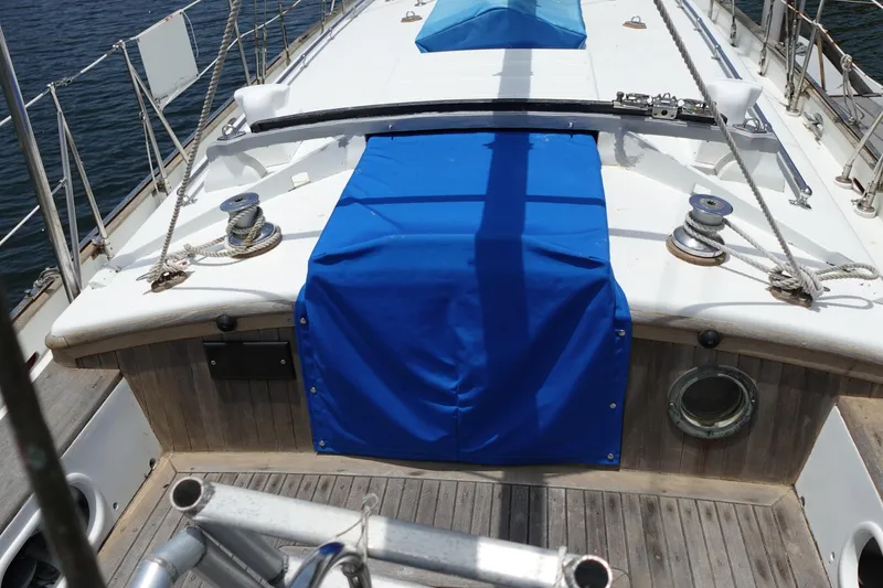 Slide: The Image of 1985 Tayana 37 Cutter sailboat deck with blue cover and winches. - 11