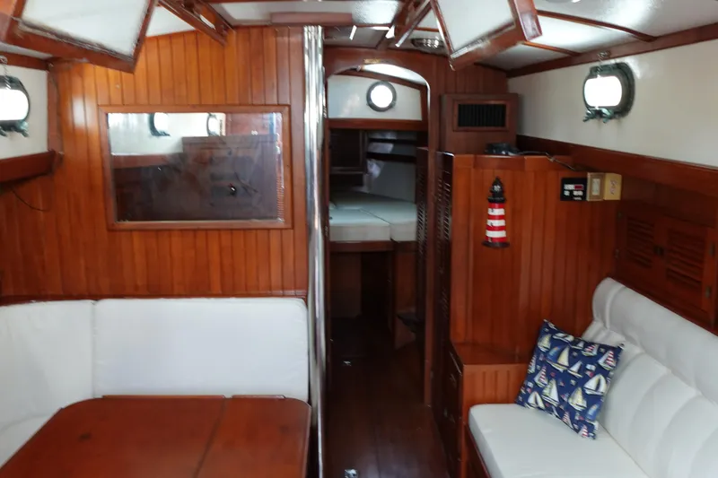Slide: The Image of Interior of 1985 Tayana 37 Cutter sailboat with wooden paneling and cozy seating area. - 15