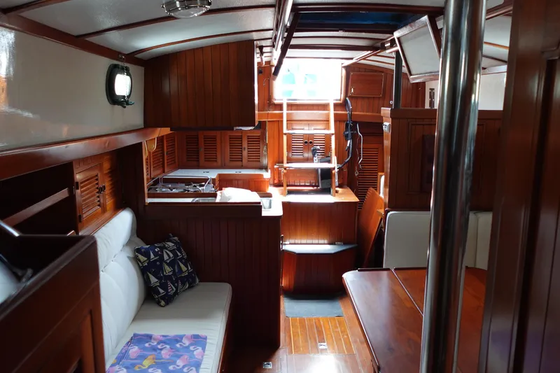 Slide: The Image of Interior of 1985 Tayana 37 Cutter sailboat with wooden finishes and cozy seating area. - 16