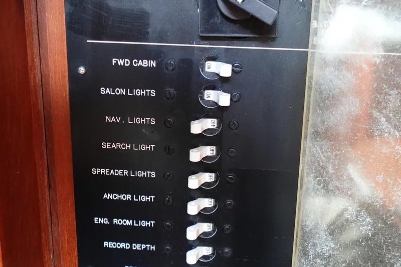 Slide: The Image of Control panel of 1985 Tayana 37 Cutter with labeled switches for various lights and functions. - 21