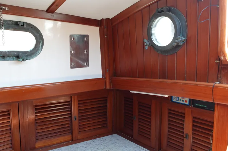 Slide: The Image of Interior of 1985 Tayana 37 Cutter with wooden paneling and portholes. - 34