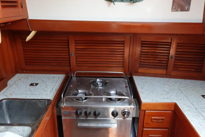 Slide: The Image of Galley kitchen in 1985 Tayana 37 Cutter sailboat with stove and wooden cabinetry. - 40