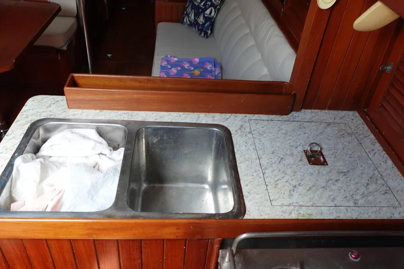 Slide: The Image of Galley sink area in 1985 Tayana 37 Cutter sailboat with wooden cabinetry. - 43