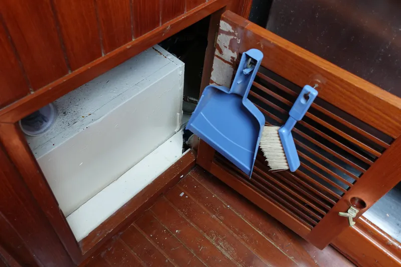 Slide: The Image of Interior of 1985 Tayana 37 Cutter with wooden paneling and cleaning tools. - 48