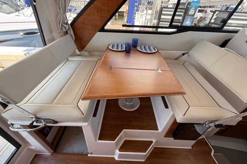 Slide: The Image of Interior of 2026 Cutwater C-288 CB boat with dining area and wooden table. - 11