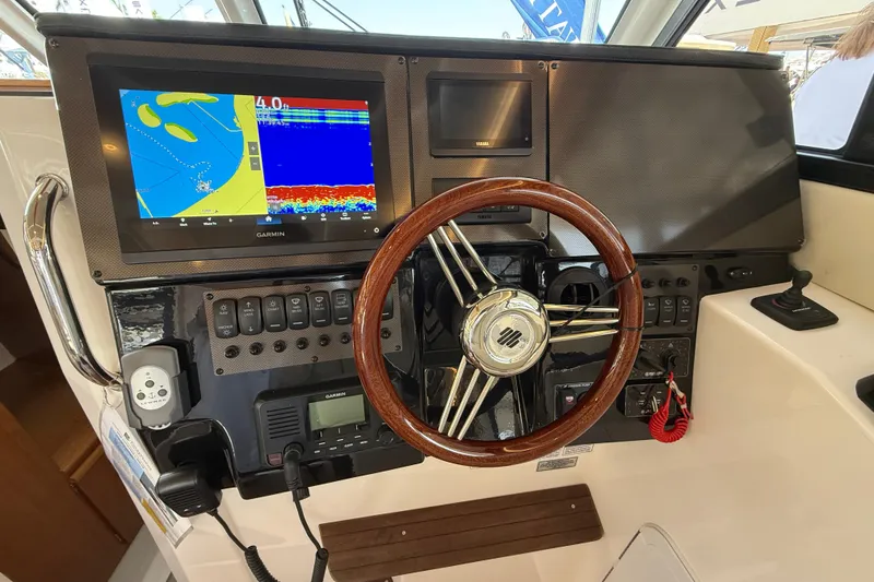 Slide: The Image of 2026 Cutwater C-288 CB helm with Garmin navigation display and wooden steering wheel. - 13